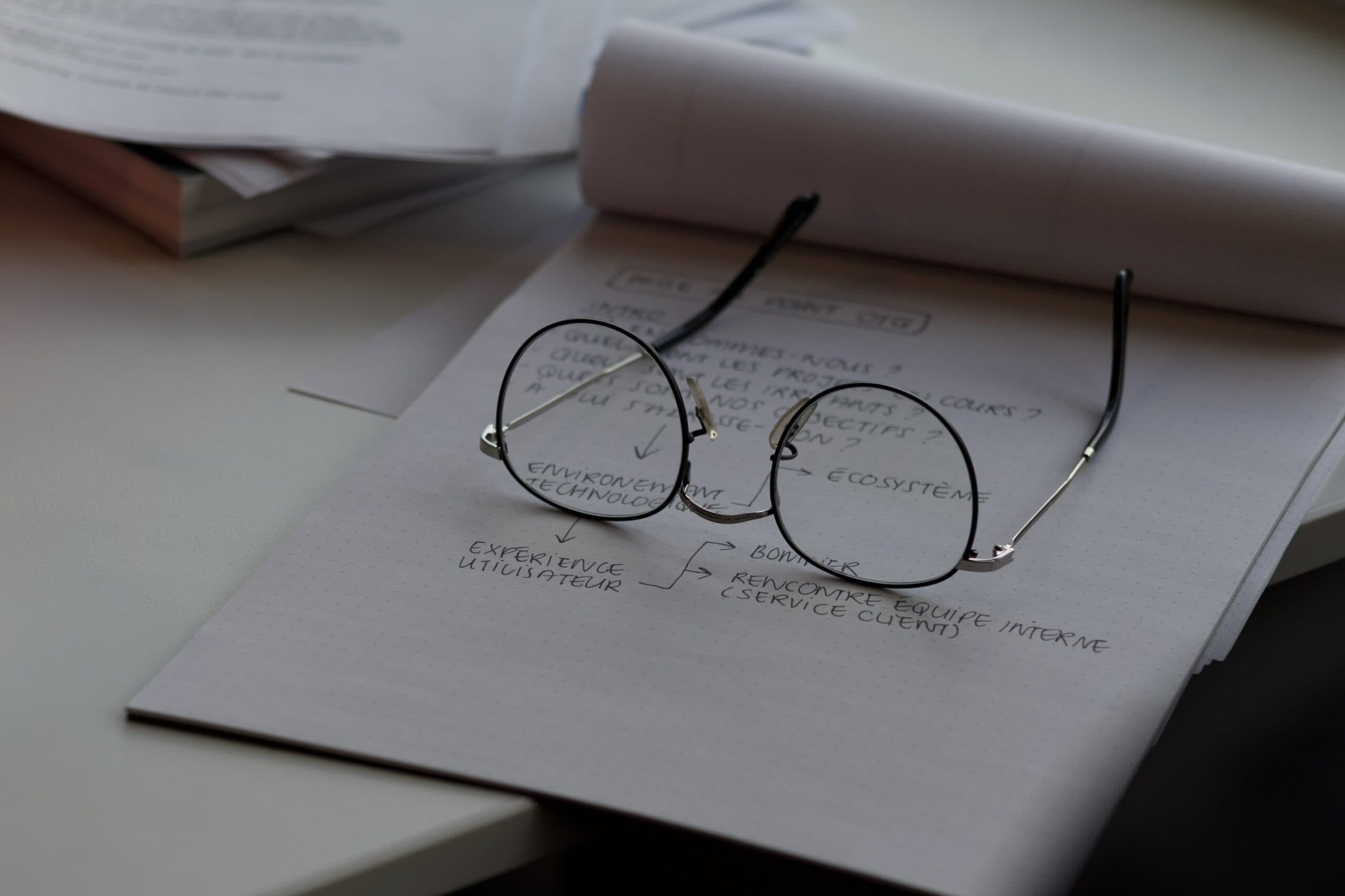 pair of glasses on a desk with documentation under it